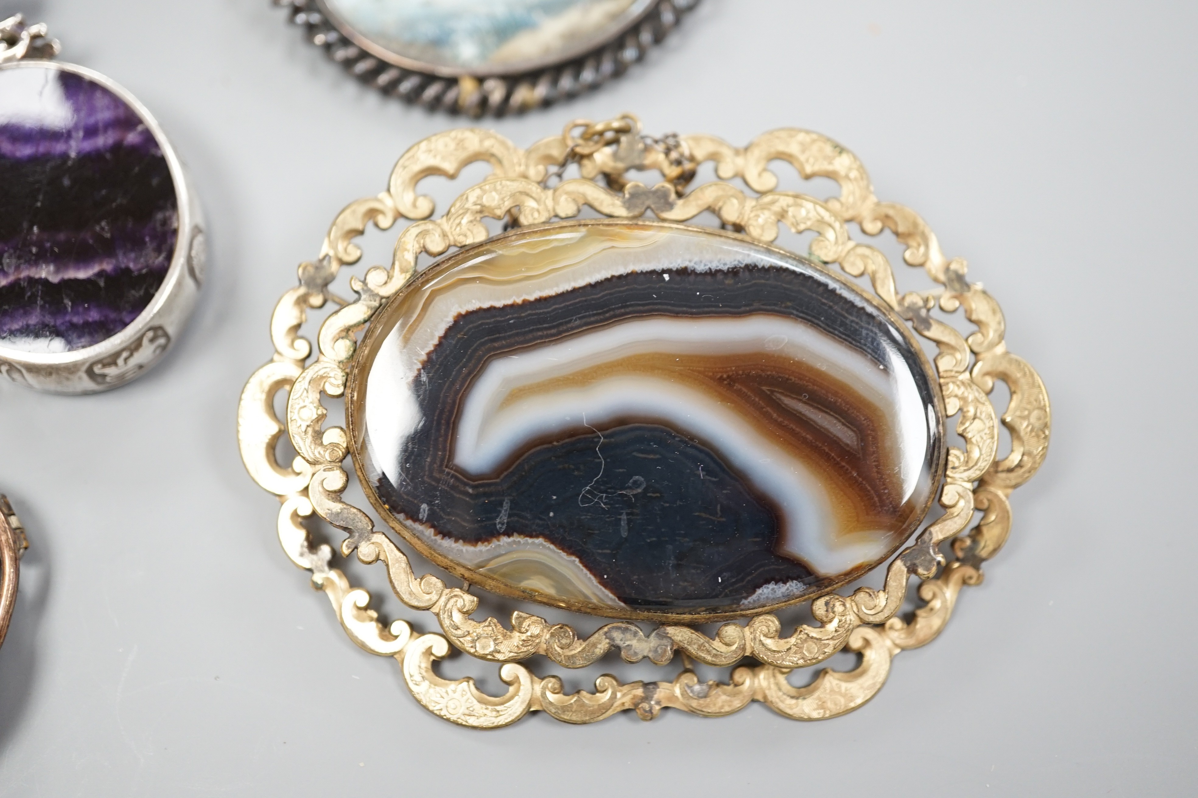 A modern silver mounted bluejohn oval pendant and three other brooches including banded agate.